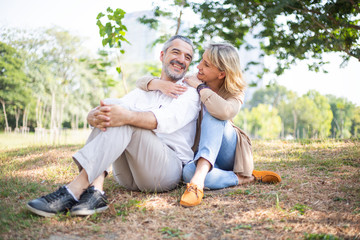 Senior elderly Caucasian couple sitting on ground together in park, wife talking with husband, Love life goals, Beautiful old retired people activity in autumn, concept for lifestyle insurance