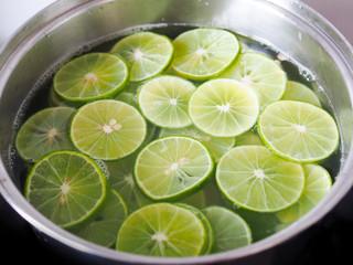 Top view of a slice of green lime, Sliced ​​lemon in boiling water pot.