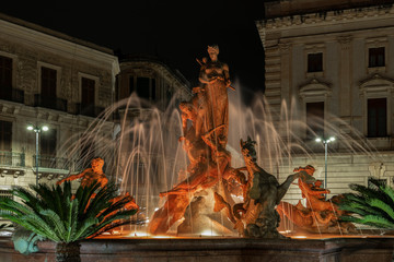 Fountain Diana with back lights and illumination in the center of square Archimede in Ortygia island at night in Syracuse in Sicily
