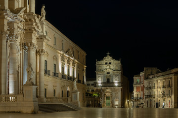 View of the main square (Piazza Duomo) of Ortygia island and facade of the catholic church of Saint Lucia alla Badia at night in Syracuse in Sicily