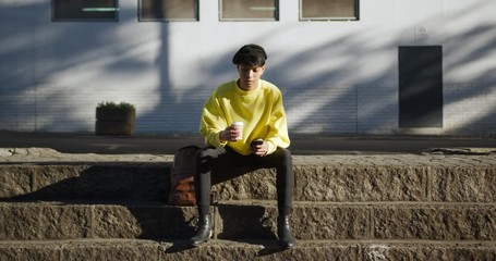 Transgender adult drinking coffee in the street - Powered by Adobe