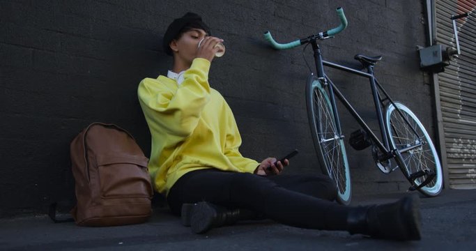Transgender adult  drinking coffee in the street
