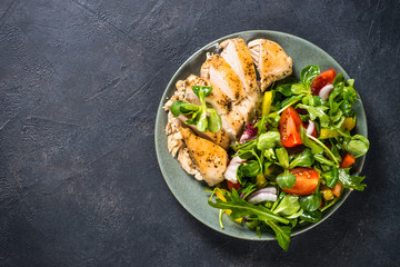 Baked chicken with fresh salad top view.