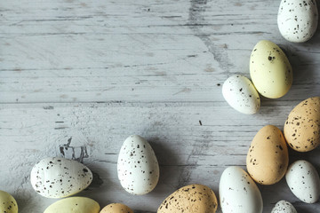 Flat lay composition of Easter eggs on light wooden background, space for text. Happy Easter Spring...