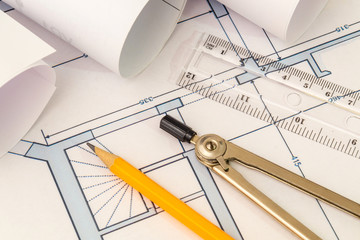 Rolled house diagrams and accessories for drawing lying on construction drawing