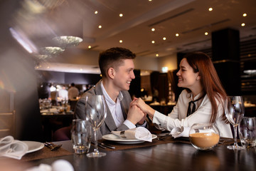 married couple celebrate anniversary in restaurant. happy handsome man and beautiful woman in love. couple enjoy dinner in luxury place. love, relationships, anniversary, holidays concept.