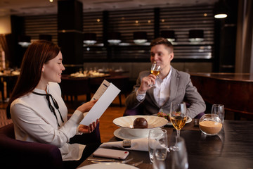 beautiful caucasian couple on a date in rich restaurant. they have dinner together, eat delicious tasty food and drink champagne. happy married couple indoors