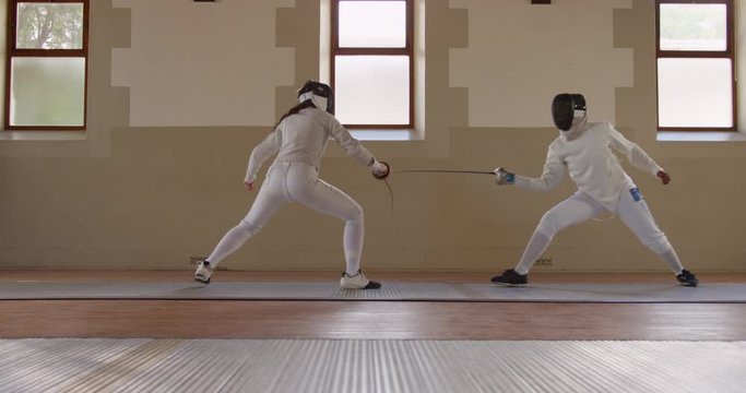 Fencer athletes during a fencing training in a gym