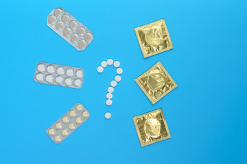 Contraceptives: condom and birth control pills on a blue background choosing contraception. Concept of birth control. medical concept, layFlat