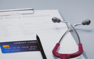 top view picture of medical billing statement, cradit card,  and pink stethoscope on the gray background