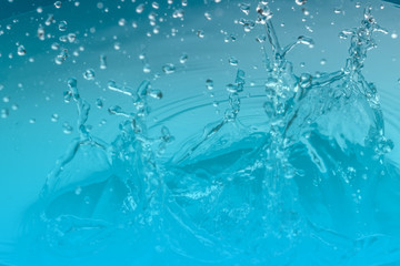 Fototapeta na wymiar Drop of water on blue background.Water splash wallpaper.