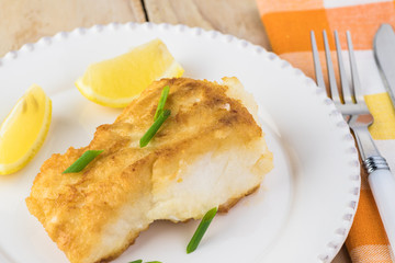 Fried light breaded cod fish.