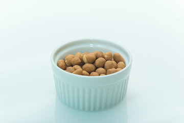 Roasted salty peanuts on white background with copy space.