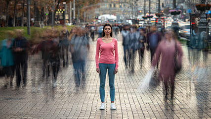 The young girl stands on the crowded urban street