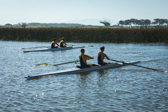 Teammates rowing on the water together