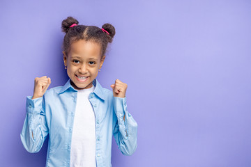 portrait of excited child girl isolated on purple background. little girl smile, she is happy to get gift or surprise on her birthday
