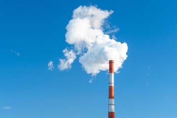 industrial smoke from a chimney in the blue sky. space for text, copy space