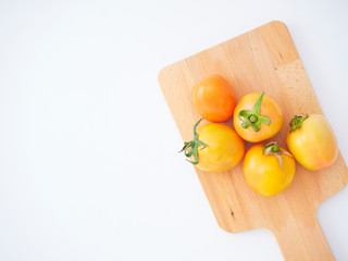 Fresh tomatoes on wooden cutting board.