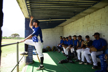 Baseball players relaxing in dugout before match