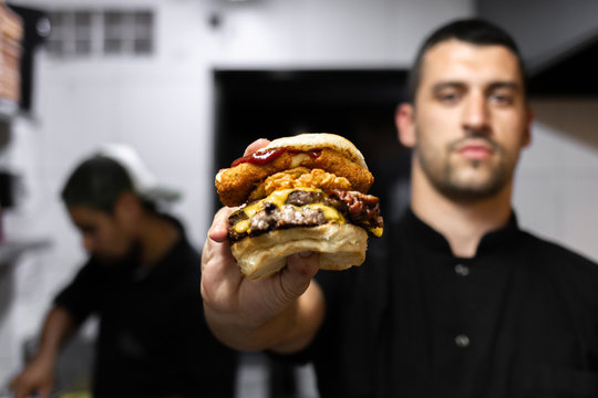 professional latin chef holding a prepared hamburger