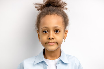 close-up portrait of shy little girl isolated over white background. cute girl with curly hair...
