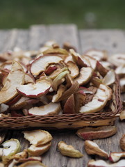Background of dried homemade fruit Apple chips or slices on a wooden background. Health benefits of dried fruits.Vegetarian food.