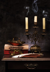 Still life with books, antique candlestick, Feather pen, envelopes and press papier. Writer Accessories Set