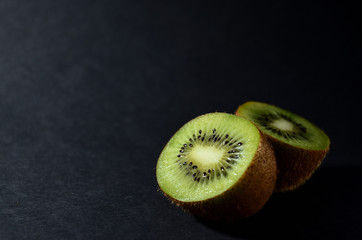half green kiwi on a grey background close-up horizontal orientation