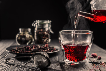 Process brewing red karkade tea,rose tea ceremony,Cup of freshly brewed fruit tea, dark moody.Hot...