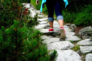 Closeup of red hiking boots on stone hiking trail . Woman hiking in High tatras mountains          