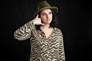 Attractive young woman dressed casually showing call me gesture