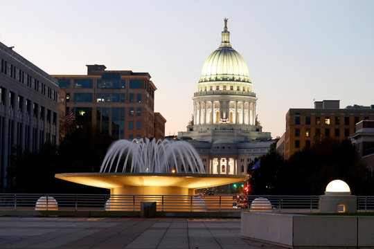 Wisconsin State Capitol building. National Historic Landmark. Madison, Wisconsin, USA. Twilight scene with  illuminated fountain in the foreground. Vertical view from Monona terrace balcony.