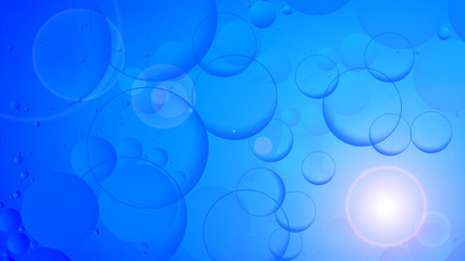 bright oily drops in water with colorful background, close-up 