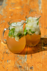 two mugs with mojito on wooden table