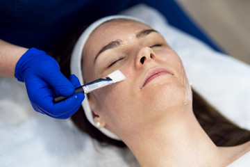 The girl does the procedure in the beauty salon. Alginate mask, ultrasonic cleaning. Facial skin...