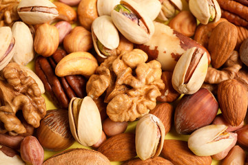 Different delicious nuts as background, closeup view