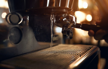 Boiling water pouring from coffeemachine, close up side view photo. problems with coffee machine