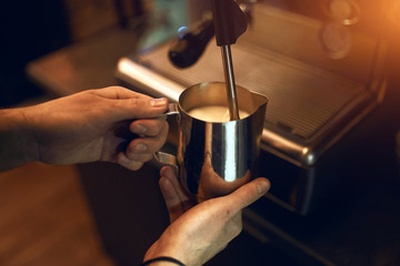 Fototapeta na wymiar professional barista pouring tasty hot coffee, close up side view photo
