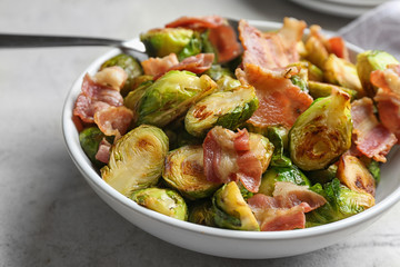 Delicious roasted Brussels sprouts with bacon served in bowl, closeup