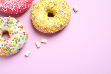 Delicious glazed donuts on lilac background, flat lay. Space for text