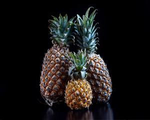 Pineapples are different on black background. Exotic fruit. HLS. Selective focus. Сloseup.