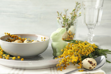 Festive Easter table setting with beautiful mimosa flowers