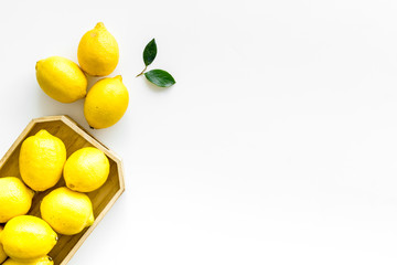 Ripe lemons in tray on white backgroud top-down frame copy space