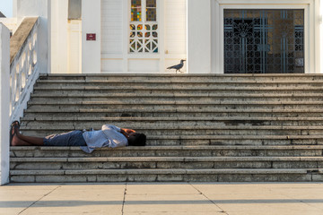 A man resting on the stairs in Maputo, Mozambique