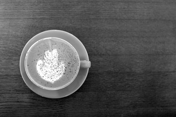 Black and white. Big Coffee cup with milk on the wooden table. cappuccino or latte drink, cup of coffee on table flat lay view. Cup of cafe au lait. Milk paintings. Hot Coffee in a blue mug