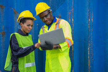 Warehouse laborer team wearing a hardhat walking cargo at the container yard and Check container integrity Before exporting products abroad. Logistics and Transportation concept.