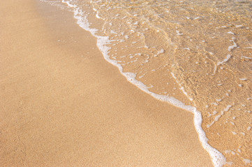 Brown Sandy beach and clear water sea with sofe waves breaking coast