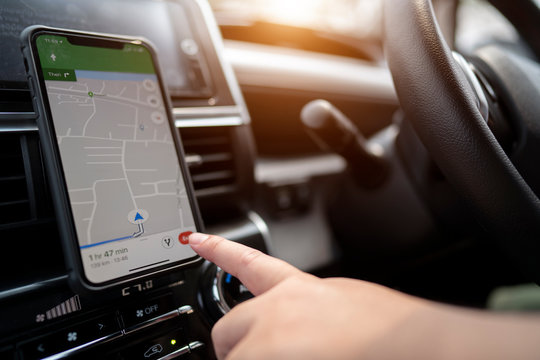 Mobile phone with map GPS navigation in car. toned at sunset.