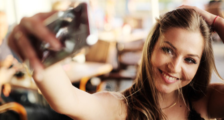 Happy young woman taking selfie outdoors