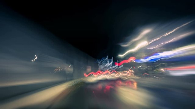 Driving fast on the German Autobahn and through a town at night, dynamic time lapse video with motion blur 